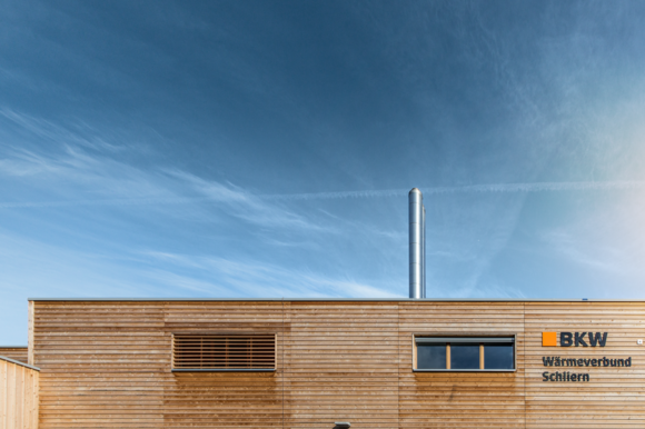 Das Holzhaus eines Wärmeverbunds vor blauem Himmel