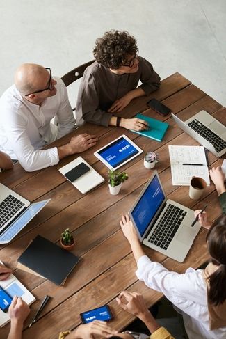 Réunion d'équipe autour d'une grande table pour les services informatiques