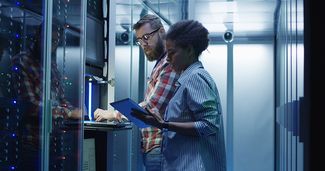 Collaborateurs IT au travail sur le rack de serveurs