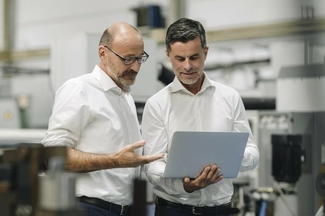 Zwei Männer betrachten etwas auf einem Laptop