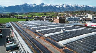Installation solaire sur le toit plat de Frutiger, montagnes avec neige en arrière-plan