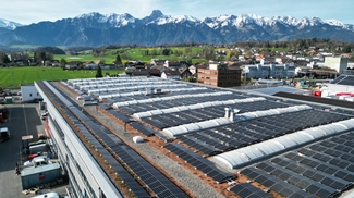 Solaranlage auf Flachdach von Frutiger, Berge mit Schnee im Hintergrund