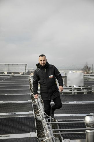 Sur les hauteurs de Kloten. Afrim Ibrahimi contrôle les capteurs solaires thermiques sur le toit du bâtiment. Photo: Sophie Stieger