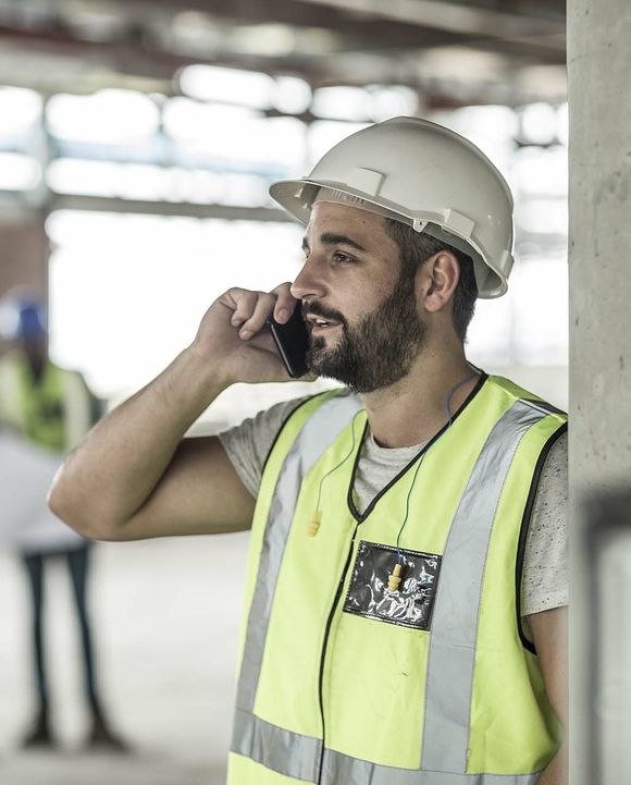 Bauarbeiter telefoniert auf der Baustelle