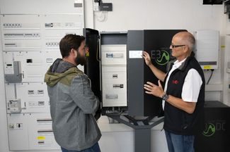Jürg Schaub (à droite) montre à Michael Zamboni les compteurs d’électricité compacts dans la cave.