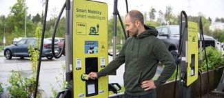 Mitarbeiter zahlt bei einer Ladestation für Elekrtoautos mit der SWISS Greencard.