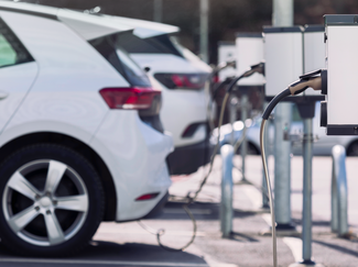 Zwei weisse Autos an Ladestation angeschlossen