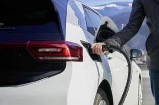 Une personne charge une voiture électrique