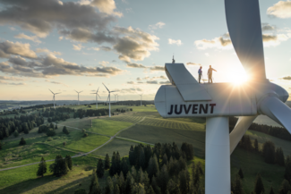 Bild von einer Windtourbine des Windparks Juvent im Berner Jura. Die Sonne geht hinter der Windtourbine unter. 