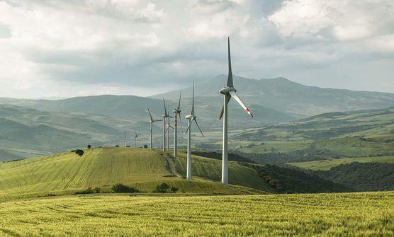 Sonnige Landschaft mit Windkraft im Vordergrund