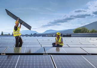 Männer installieren Solarmodule auf Dach