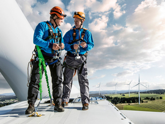 Pierre Berger se tient sur une éolienne avec des collaborateurs.