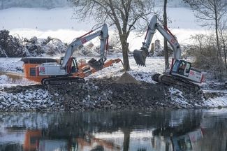 Deux pelleteuses aplanissent la rive