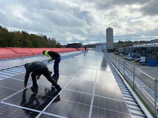 Zwei Facharbeiter legen PV-Panels auf Dach
