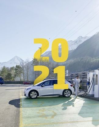 Mann lädt Auto an Elektrotankstelle auf Raststätte
