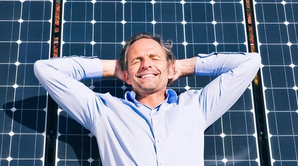 Business Person entspannt vor Solarpanel und geniesst Sonne
